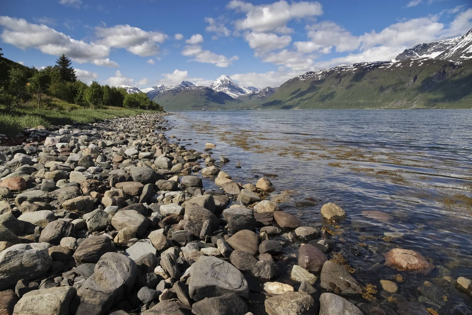 Natural rocky shoreline and snow-capped mountains at Storfjorden, Lyngen